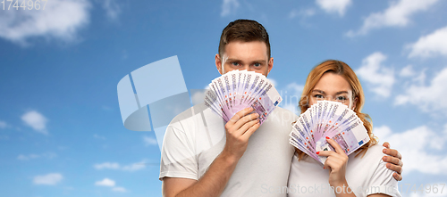 Image of happy couple in white t-shirts with euro money