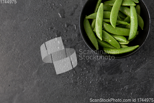 Image of peas in bowl on wet slate stone background