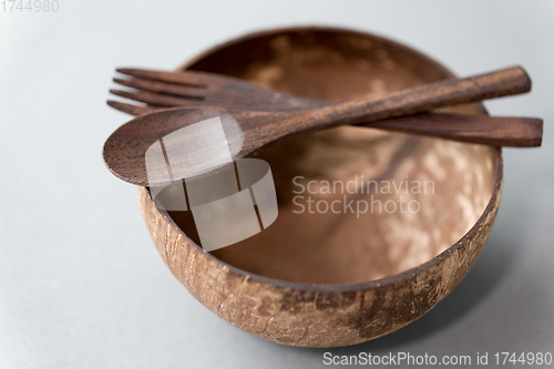 Image of close up of coconut bowl, wooden spoon and fork