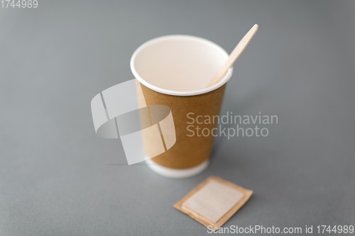 Image of disposable paper coffee cup with spoon and sugar