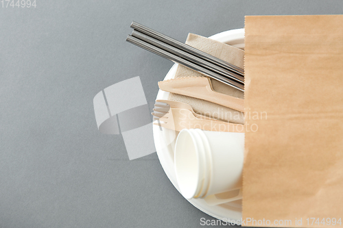 Image of wooden forks, knives and paper cups on plate