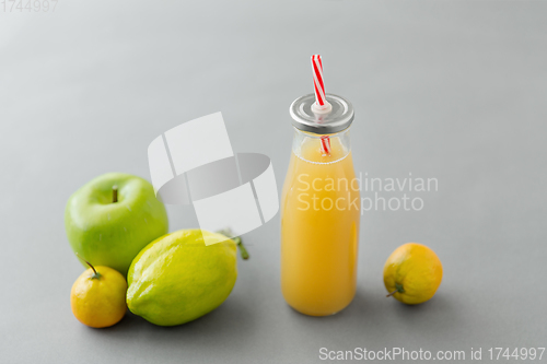 Image of reusable glass bottle of fruit juice with straw