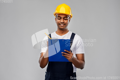 Image of happy builder in helmet with clipboard and pencil