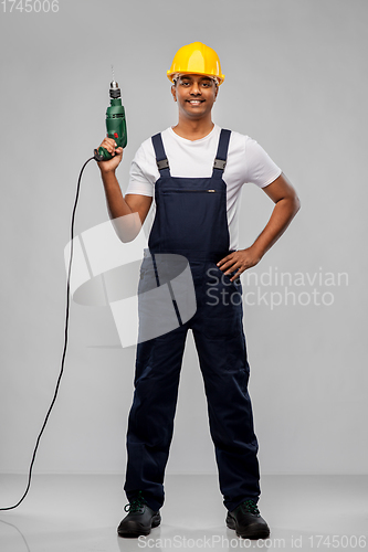 Image of happy indian builder in helmet with electric drill