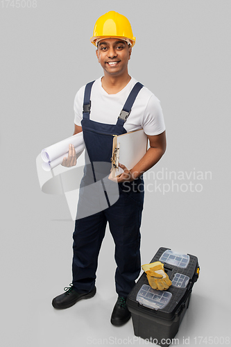 Image of happy indian builder with blueprint and clipboard