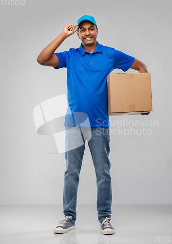 Image of happy indian delivery man with parcel box in blue