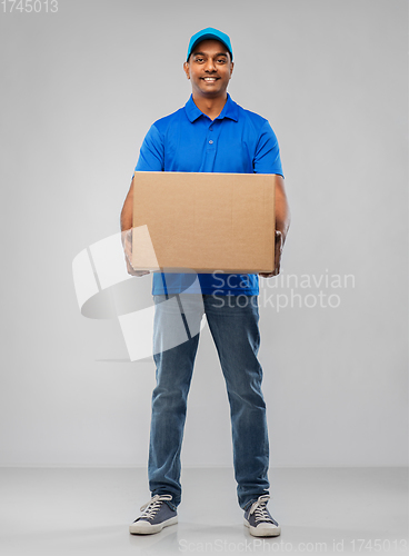 Image of happy indian delivery man with parcel box in blue