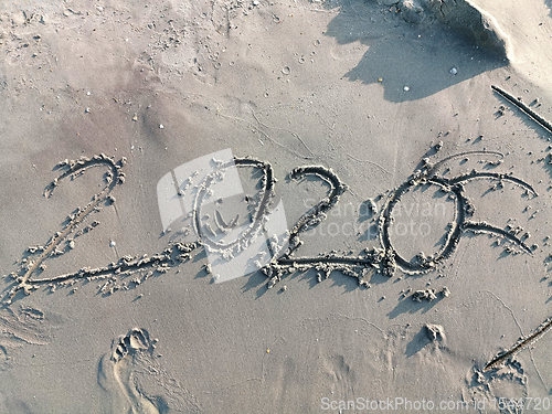 Image of Happy year 2020 on wet sand