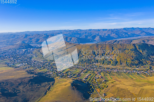 Image of Aerial view of village and autumn mountain