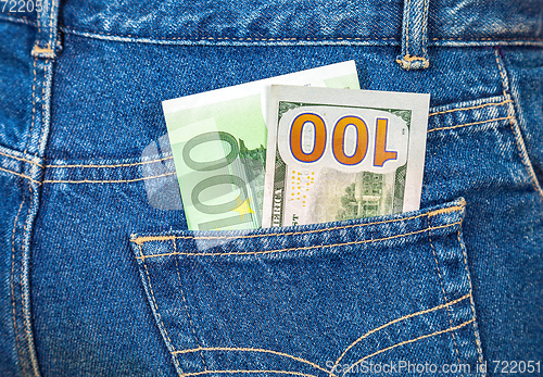 Image of Blue jeans pocket with one hundred euro and one hundred american