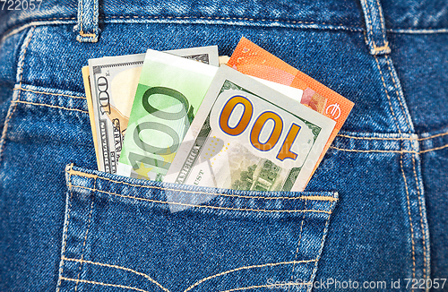 Image of Euro and american currency, money in jeans pocket for travel and