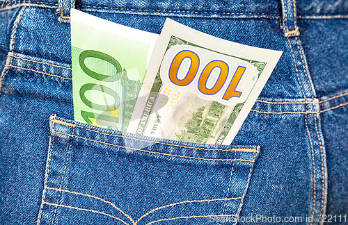 Image of Blue jeans pocket with one hundred euro and one hundred american