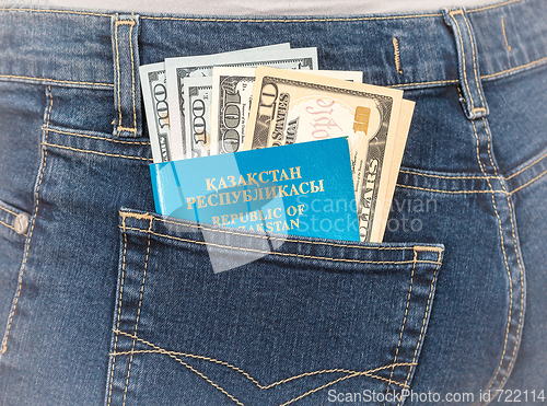 Image of Kazakhstan passport and dollar bills in the back jeans pocket. M