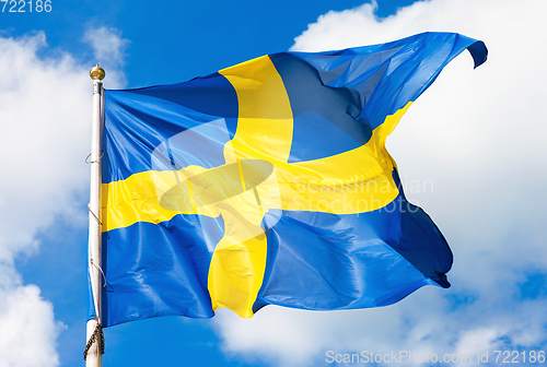 Image of Swedish flag blue with yellow cross waving in the wind against a