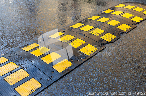 Image of Traffic safety speed bump on an asphalt road