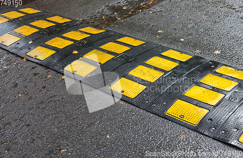 Image of Traffic safety speed bump on an asphalt road