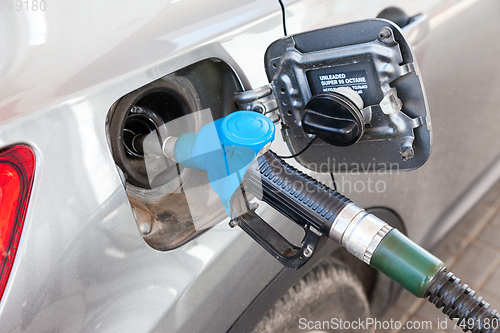 Image of Pumping gasoline fuel in passenger car at gas station