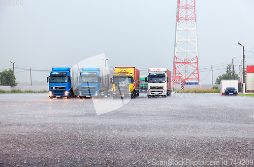 Image of Truck trailers parked up at the parking lot in heavy rain