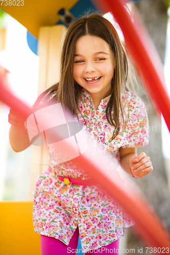 Image of Cute little girl is playing in playground