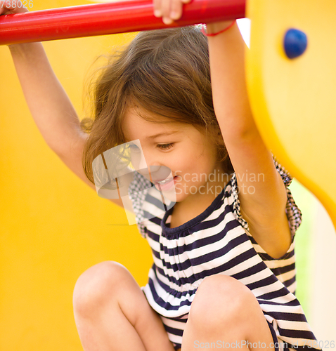 Image of Cute little girl is playing in playground