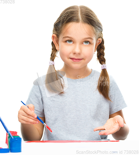 Image of Little girl is painting with gouache