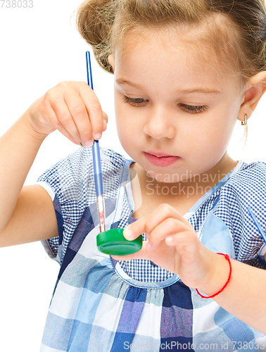 Image of Little girl is painting with gouache