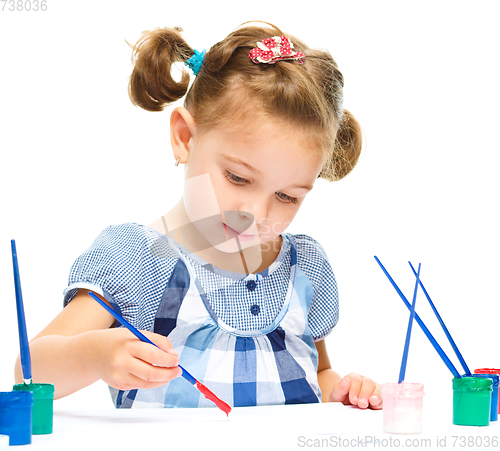 Image of Little girl is painting with gouache