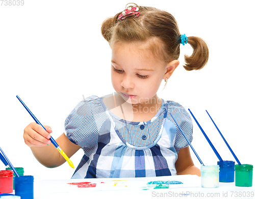 Image of Little girl is painting with gouache