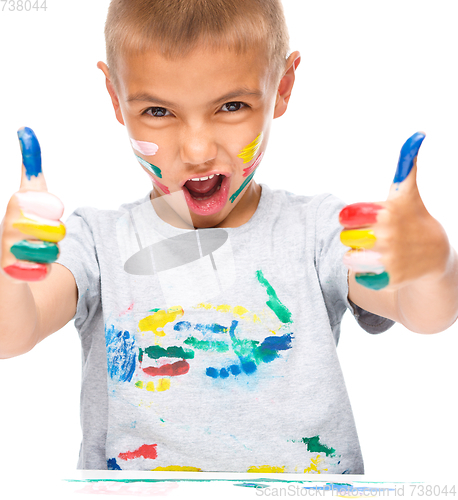 Image of Portrait of a cute boy playing with paints