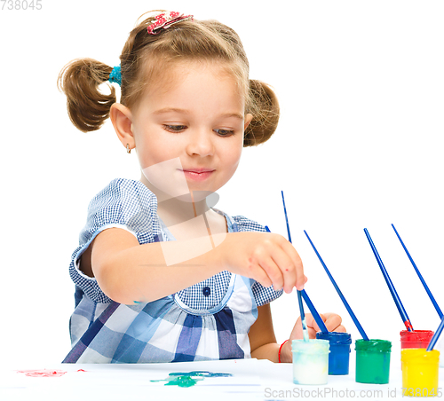 Image of Little girl is painting with gouache