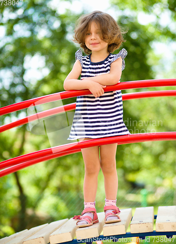 Image of Cute little girl is playing in playground