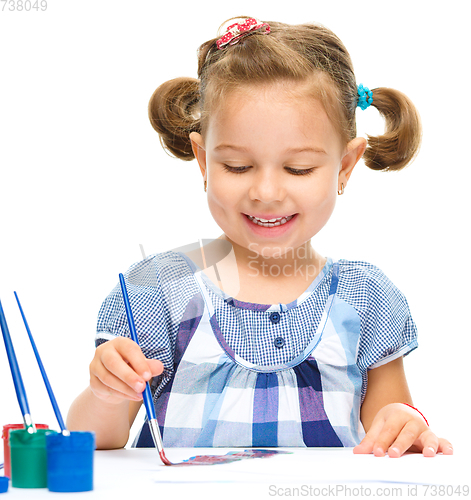 Image of Little girl is painting with gouache