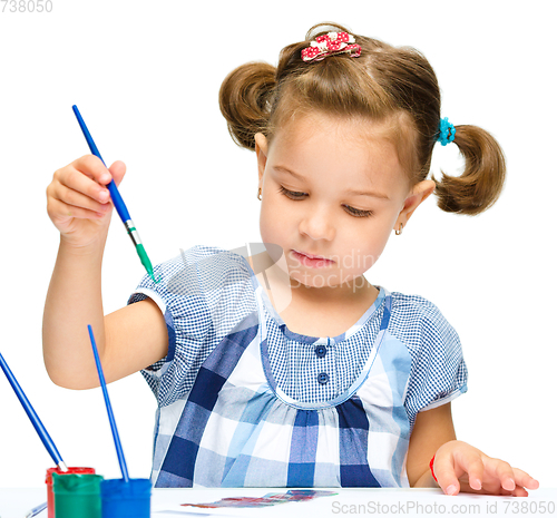 Image of Little girl is painting with gouache