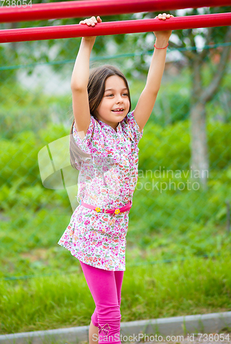 Image of Cute little girl is playing in playground
