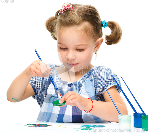 Image of Little girl is painting with gouache