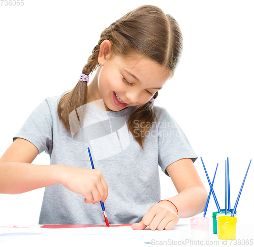 Image of Little girl is painting with gouache