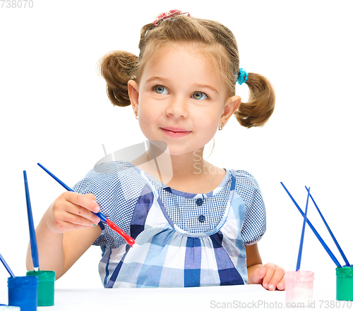 Image of Little girl is painting with gouache