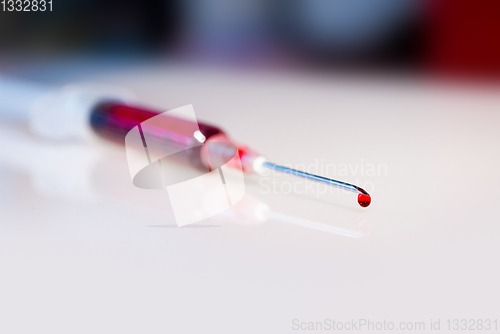 Image of Syringe needle with blood macro view