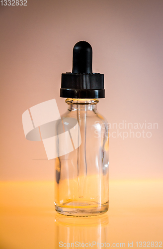 Image of Glass dropper bottle on orange background