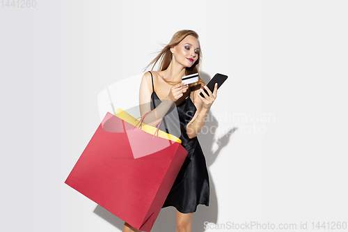 Image of Young woman in dress shopping on white background