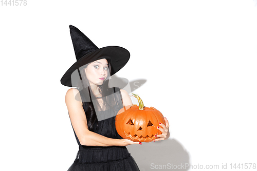 Image of Young woman in hat and dress as a witch on white background