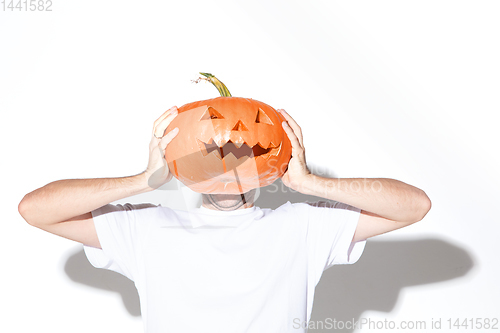 Image of Young man holding pumpking on white background