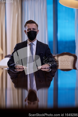 Image of business man wearing protective face mask at luxury office