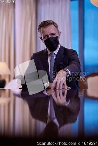 Image of business man wearing protective face mask at luxury office