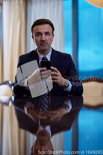 Image of business man using smart phone at luxury office