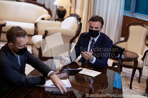 Image of business people wearing crona virus protection face mask on meeting