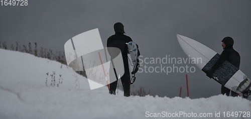 Image of Arctic surfers running on beach after surfing