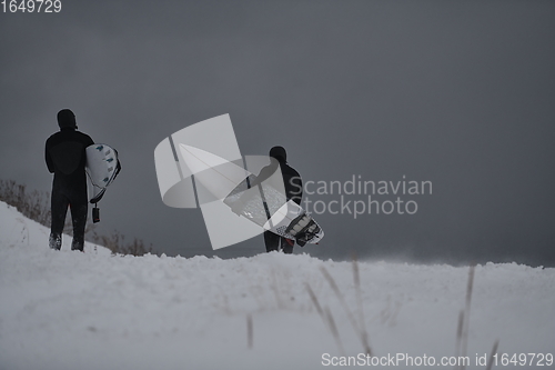 Image of Arctic surfers running on beach after surfing