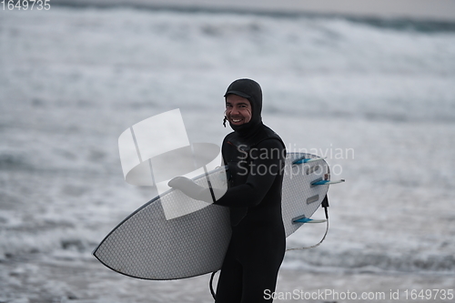 Image of Arctic surfer going by beach after surfing