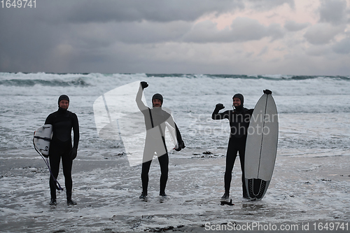 Image of Arctic surfers going by beach after surfing